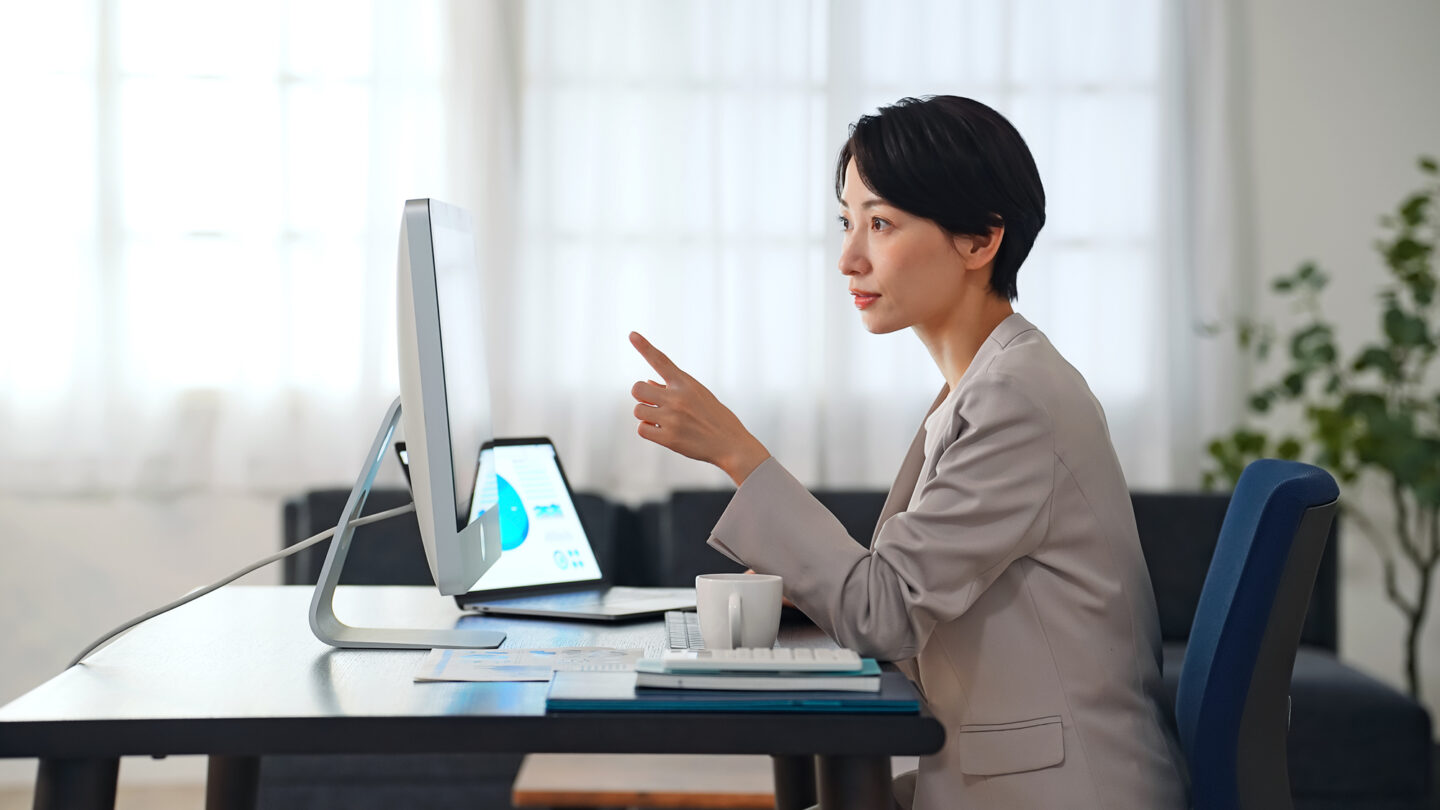 ホームオフィスでPC作業に取り組む女性の写真