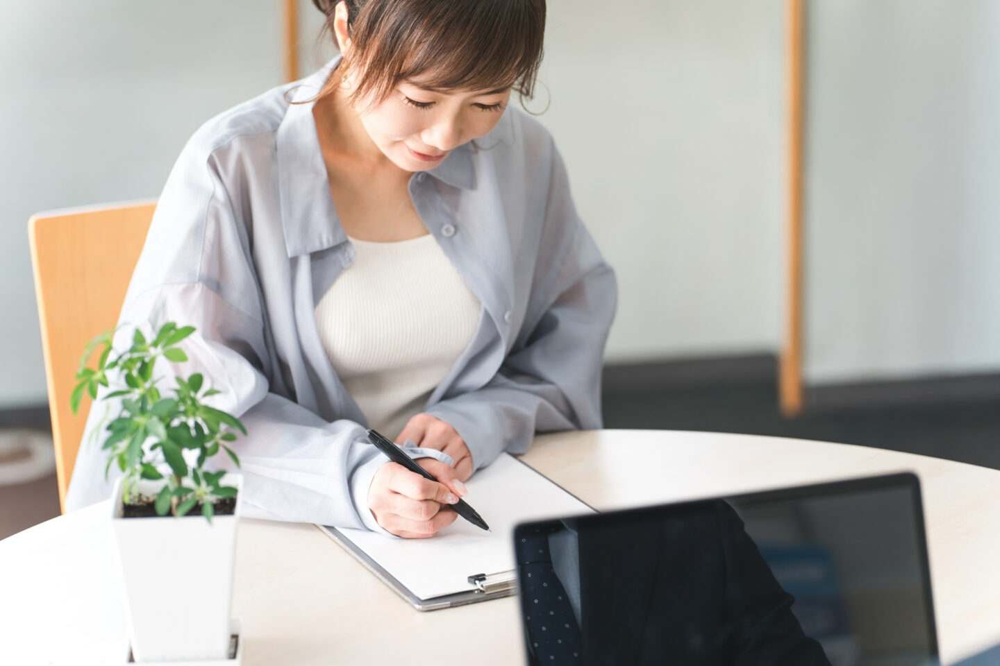 ノートに経験を書き出す30〜50代女性。スキルの棚卸しや自己分析を行うイメージ
