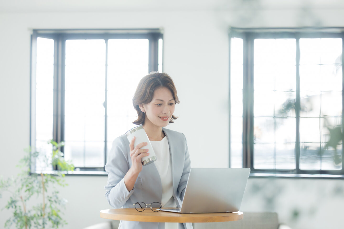 40代～50代の女性がカフェでPCに向かい前向きに働くイメージ画像
